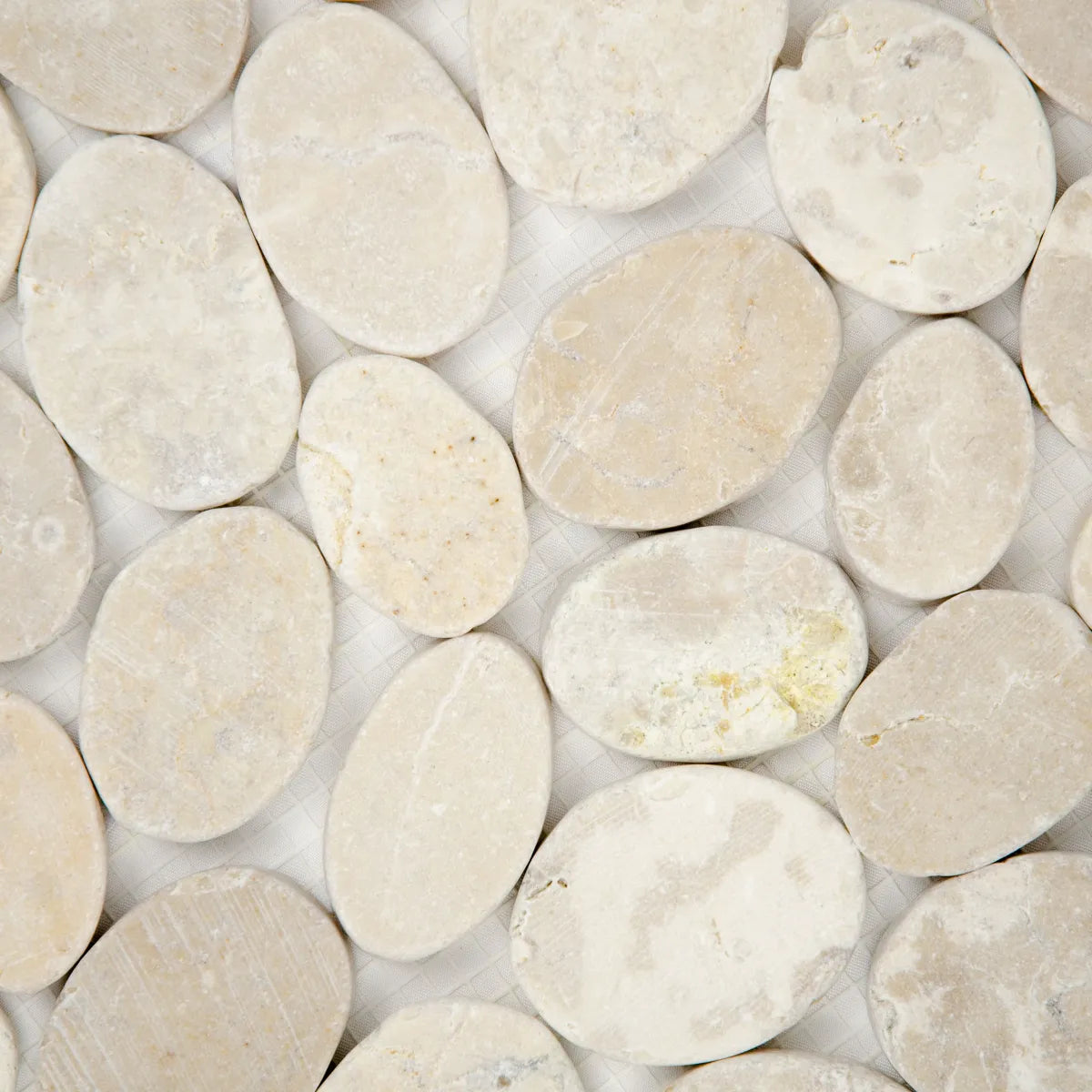 Détail galets marbre crème mosaïque joints reliefs surface pierre